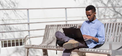 Student outside on laptop