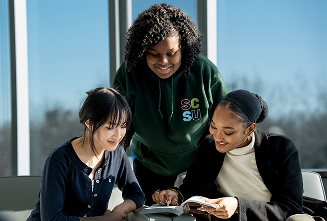 a group of women looking at a book