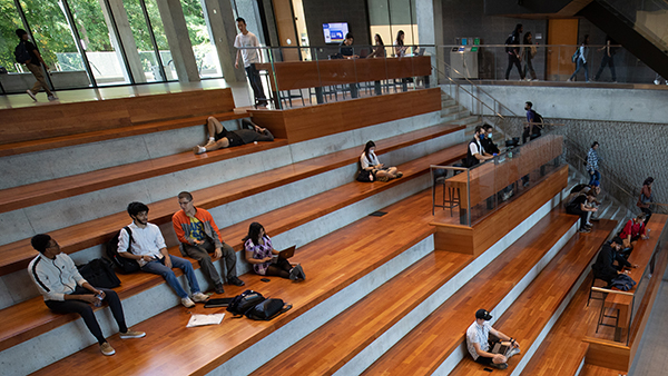 a group of people sitting on the stairs in a library