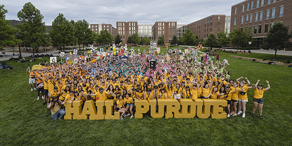 Boiler Gold Rush participants pose for large group photo on Krach lawn with giant letters that read "Hail Purdue" 